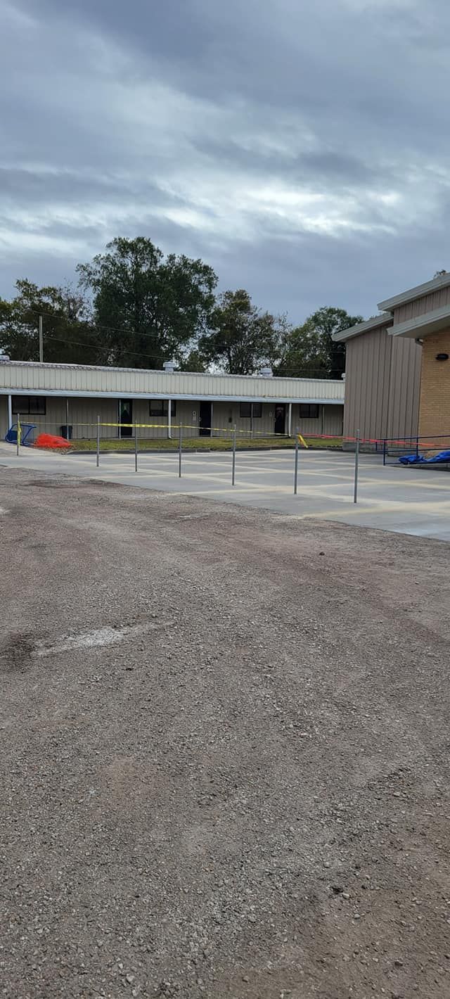 There is a building in the background and a lot of gravel in the foreground.