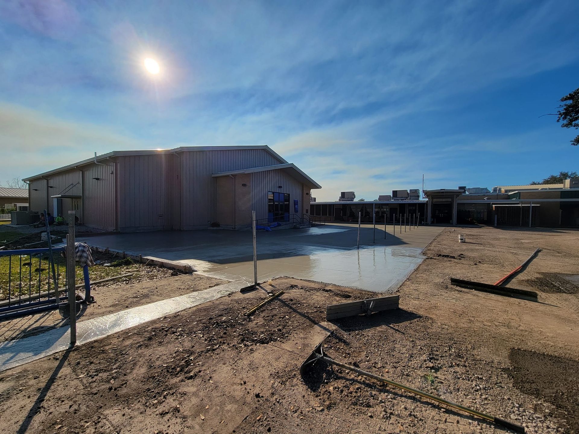 A large building is being built in the middle of a dirt field.