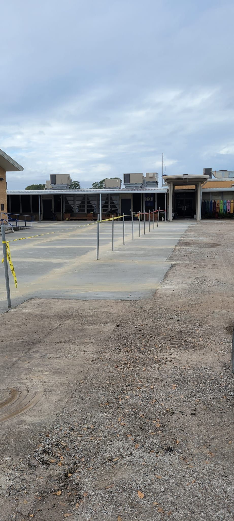 A large building is being built in the middle of a dirt field.