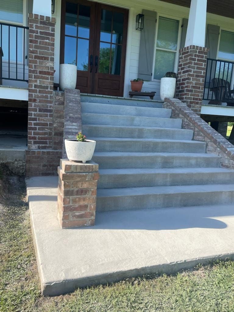 A concrete porch with stairs leading up to a house