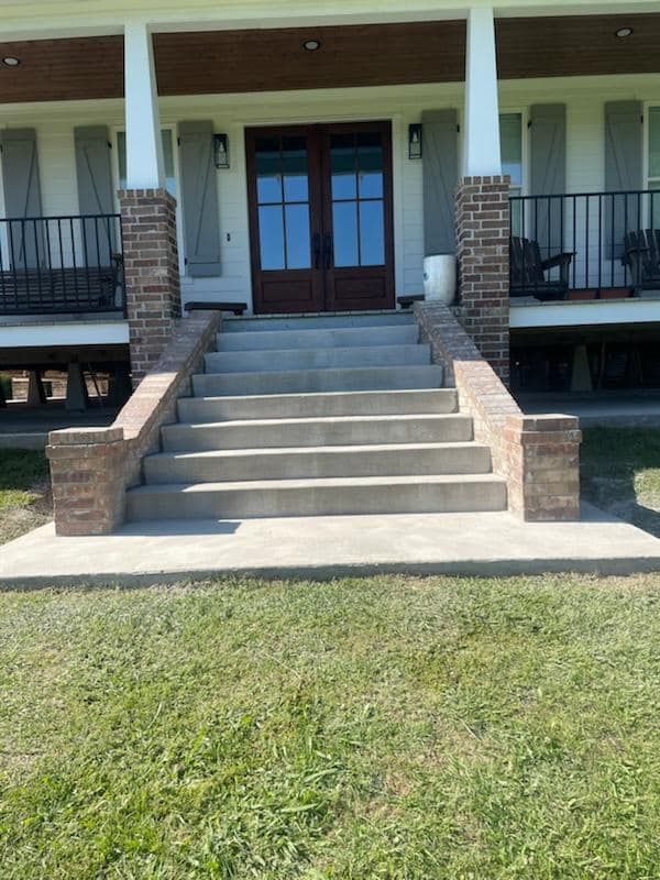 There are stairs leading up to the front door of a house.