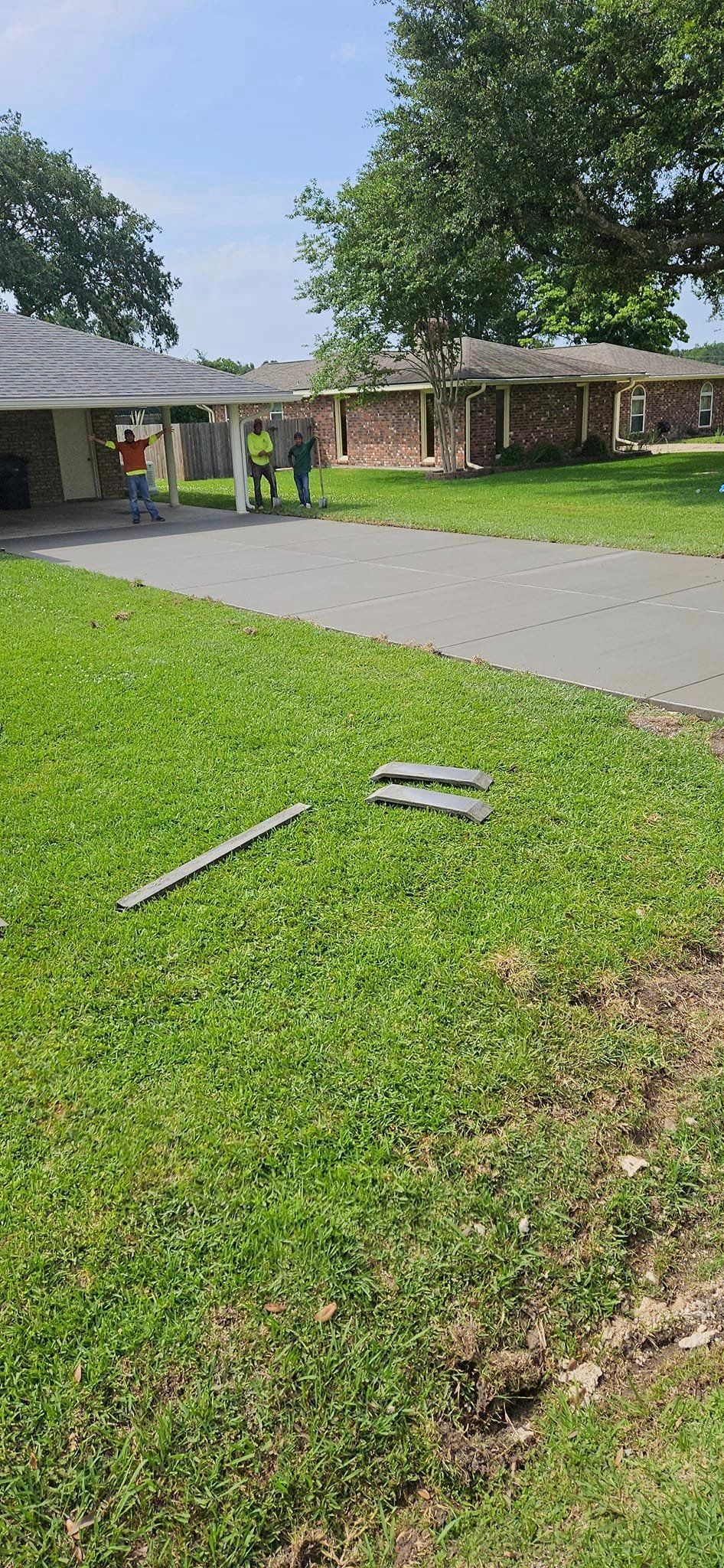 A house with a lot of grass and a driveway in front of it.