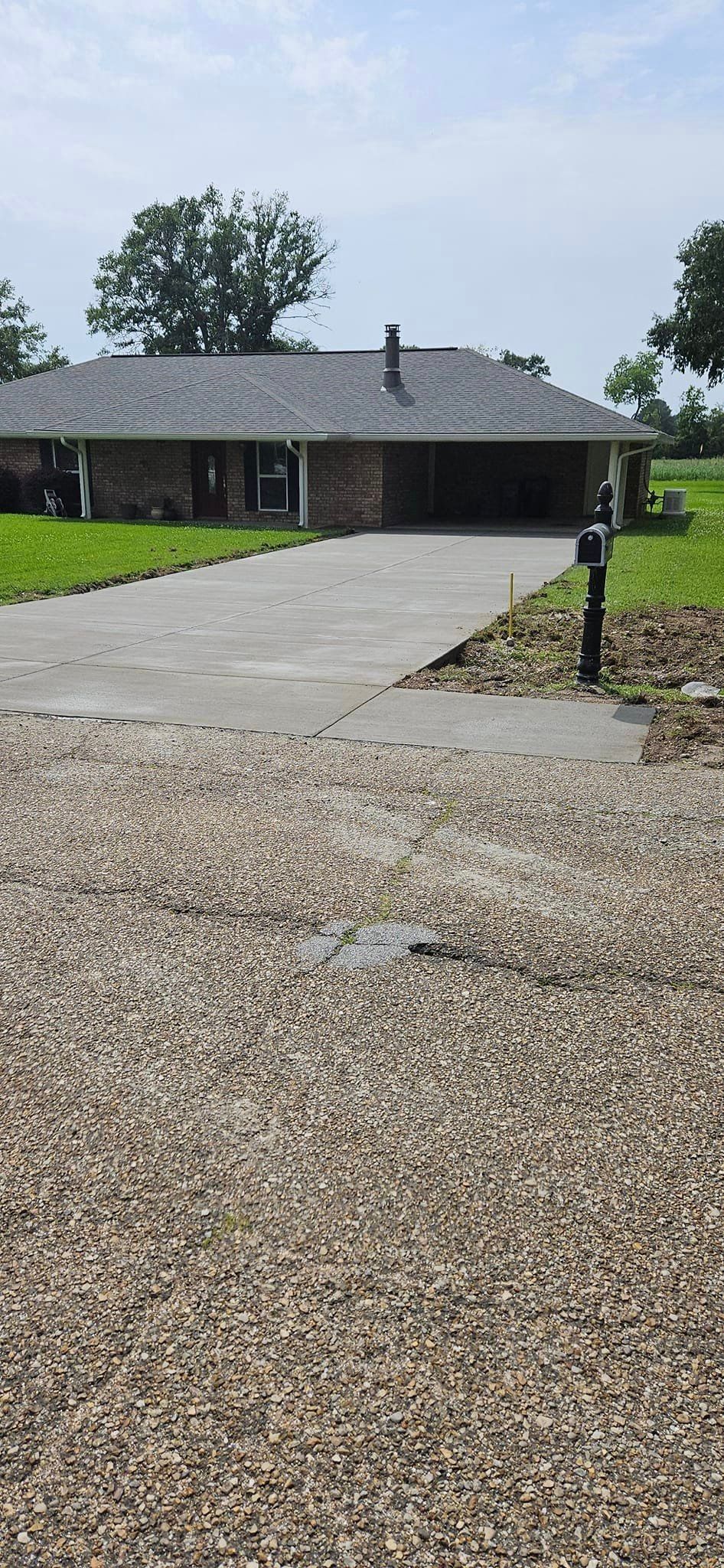 There is a gravel driveway leading to a house.