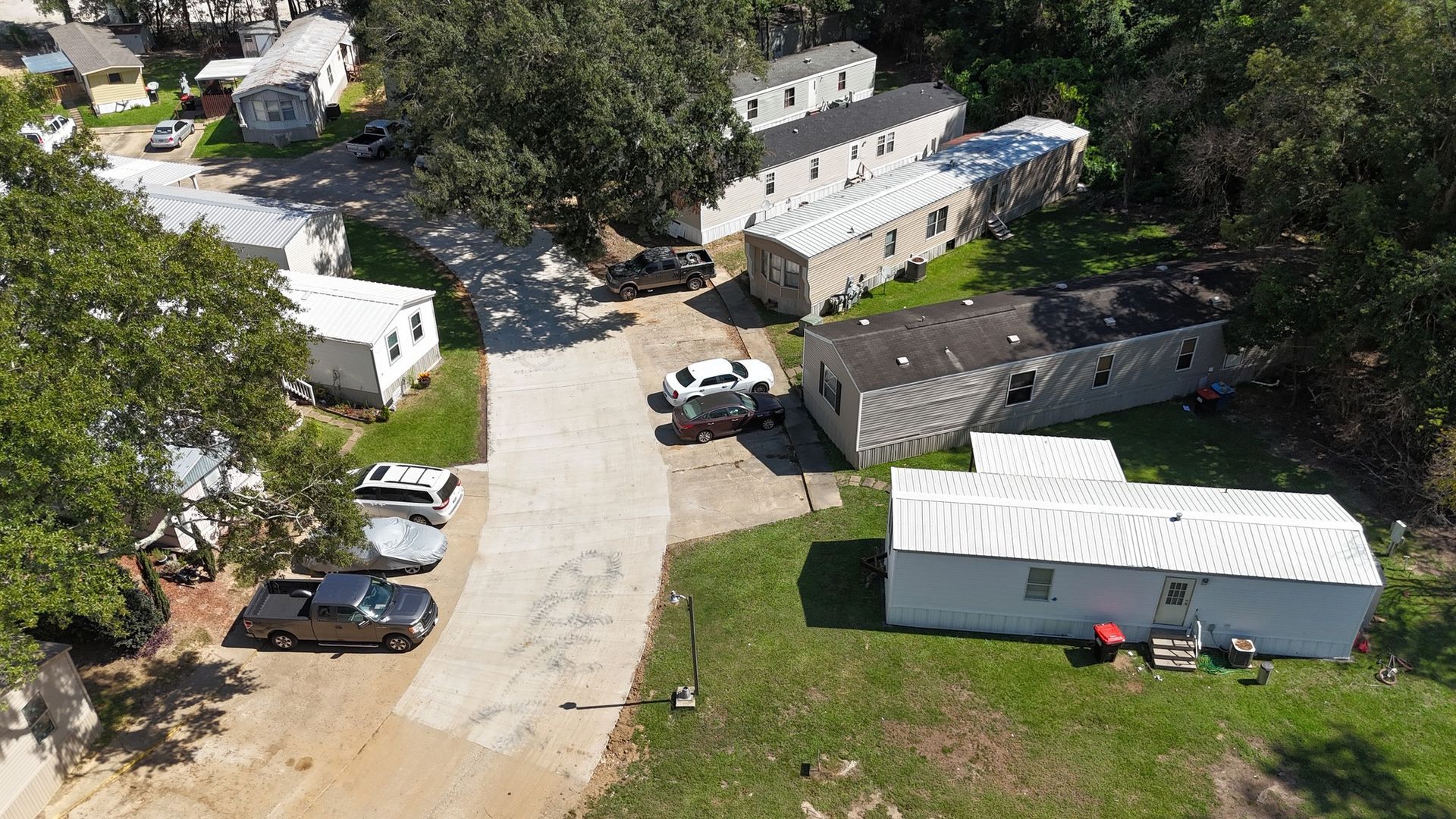 An aerial view of a mobile home park with cars parked on the side of the road.