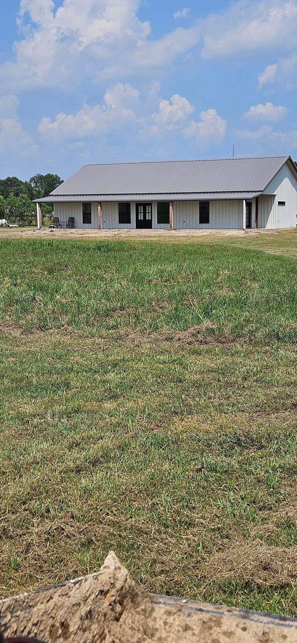 A house is sitting in the middle of a grassy field.