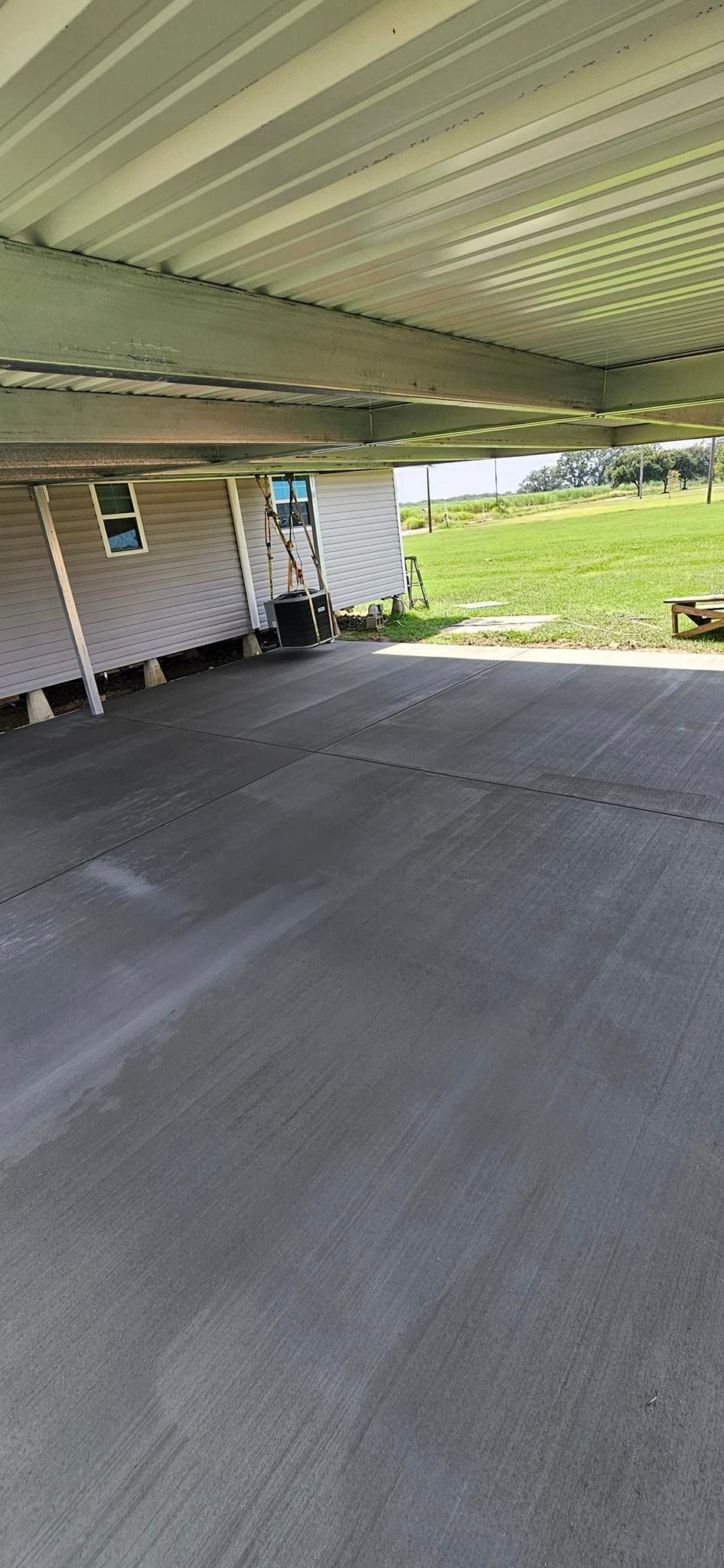 A carport with a trailer parked underneath it.