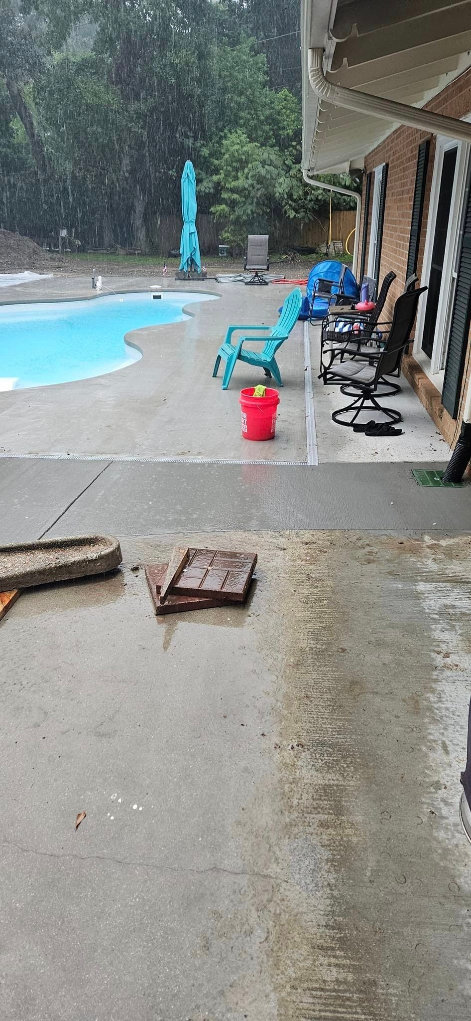 A patio with a pool and chairs in the background.