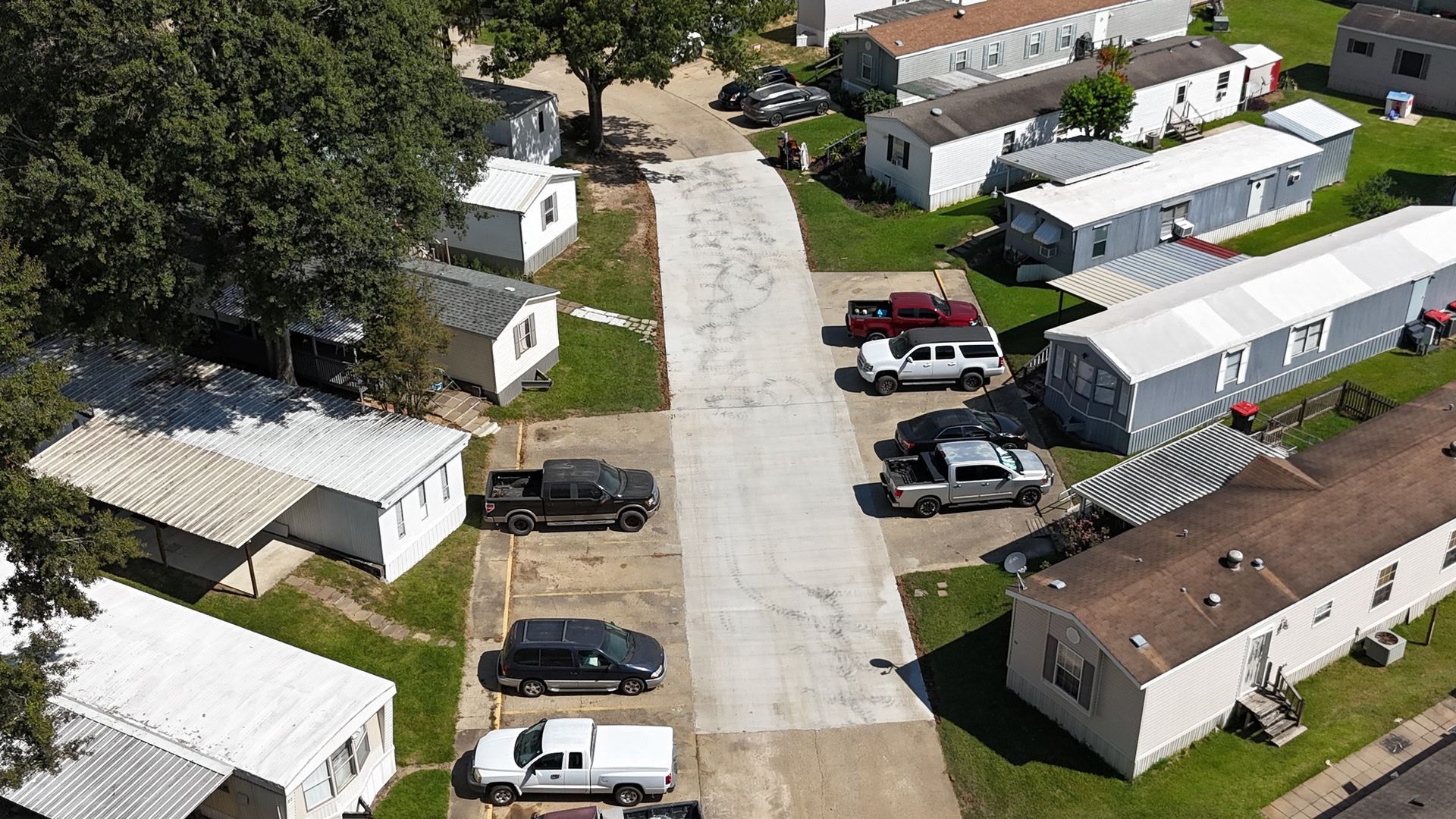 An aerial view of a mobile home park with lots of cars parked on the side of the road.