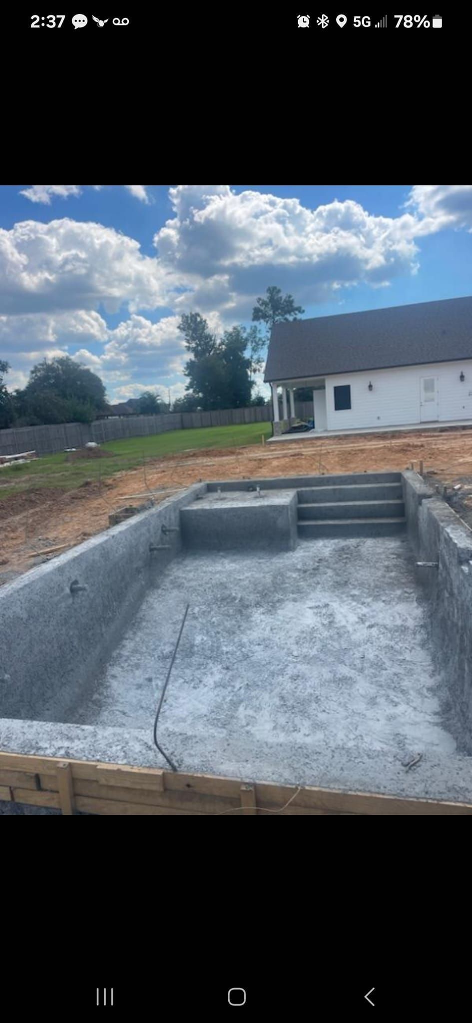 A swimming pool is being built in front of a house.