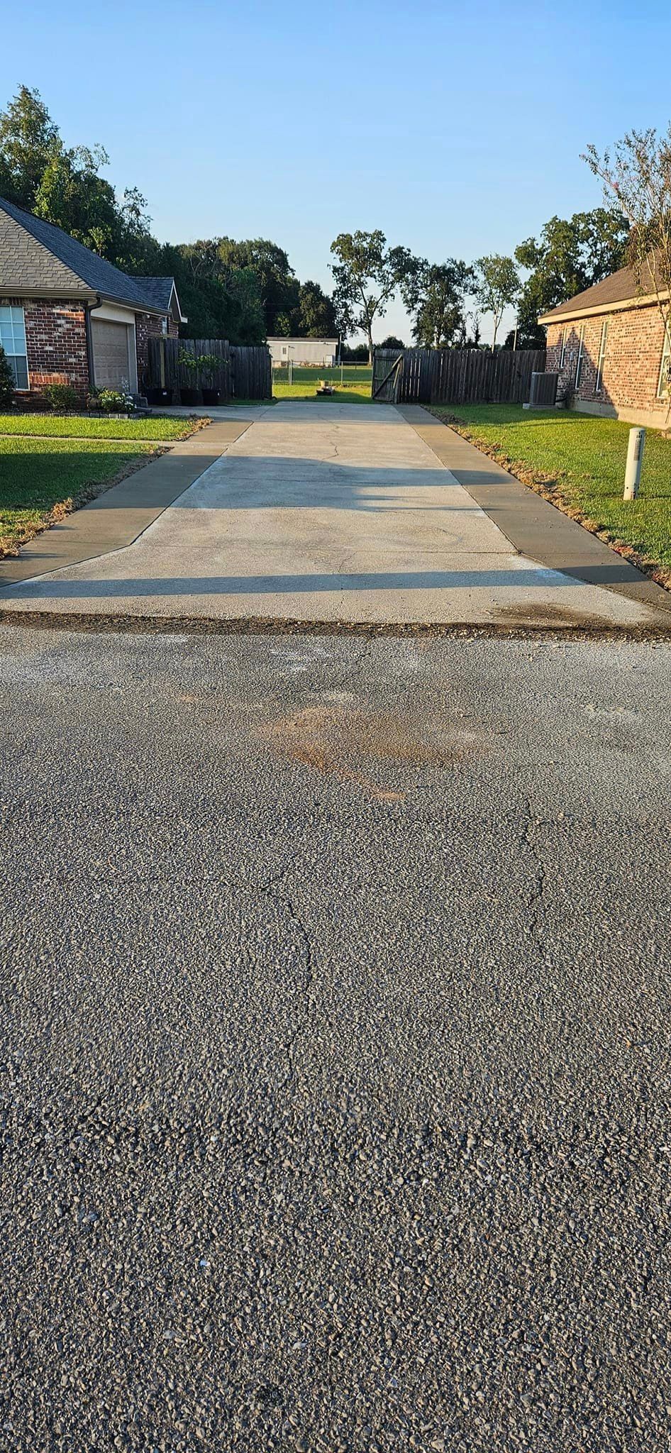 A gravel driveway leading to a house in a residential area.