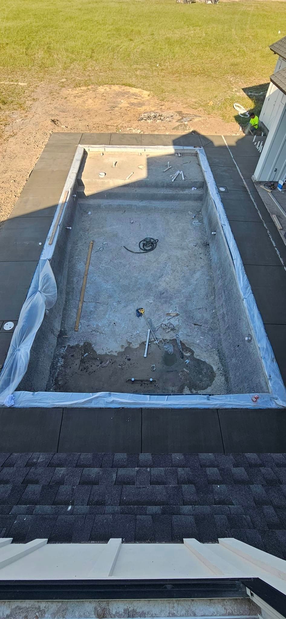 A swimming pool is being built on the roof of a house.