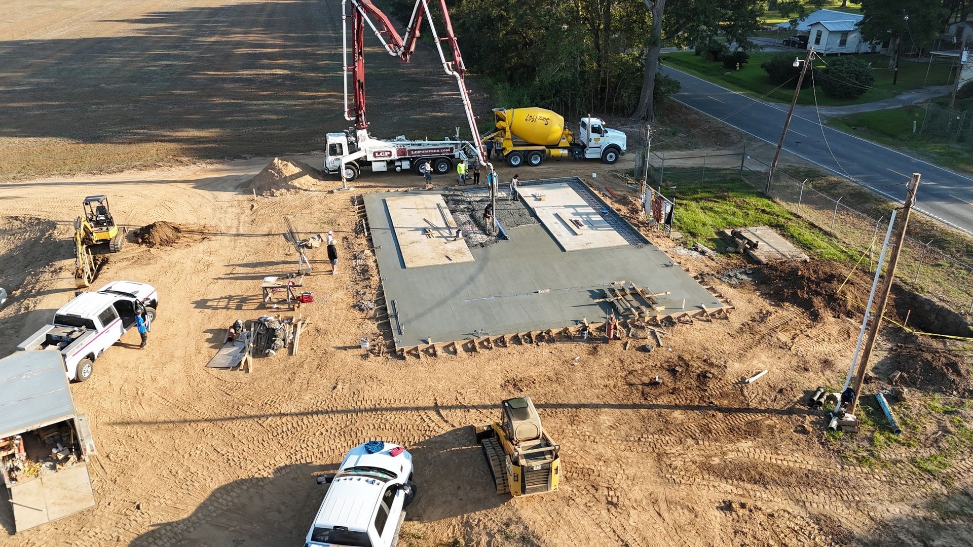 An aerial view of a construction site with concrete pumps and trucks.