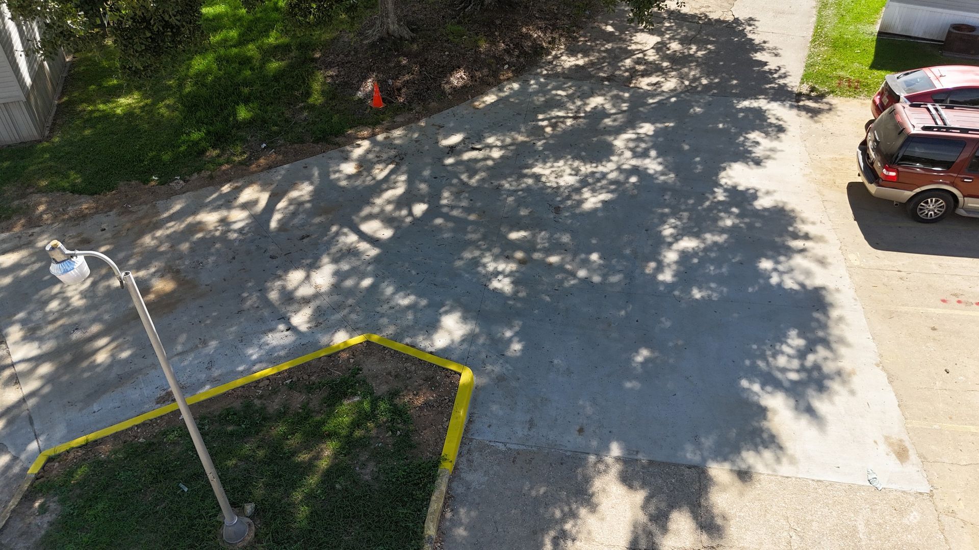 An aerial view of a red suv parked in a driveway.