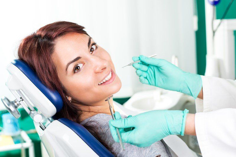 woman smiling in dentists char