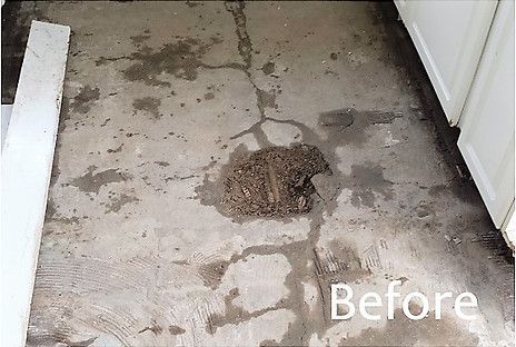 Concrete floor with cracks and dirt pile, showing before damage.