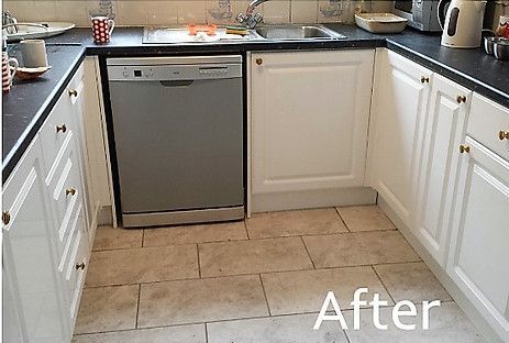 Kitchen corner with white cabinets, a dishwasher, and black countertops; beige tile floor.