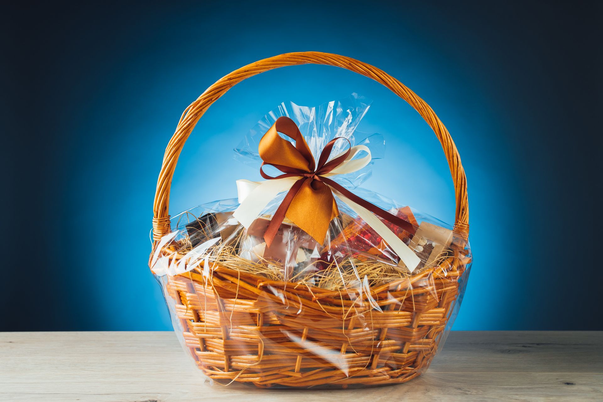 A golden-themed gift basket on a blue background. A golden-themed gift basket on a blue background.