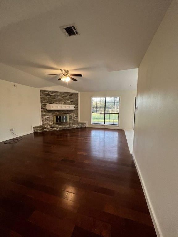 Living room with ceiling fan and fireplace.