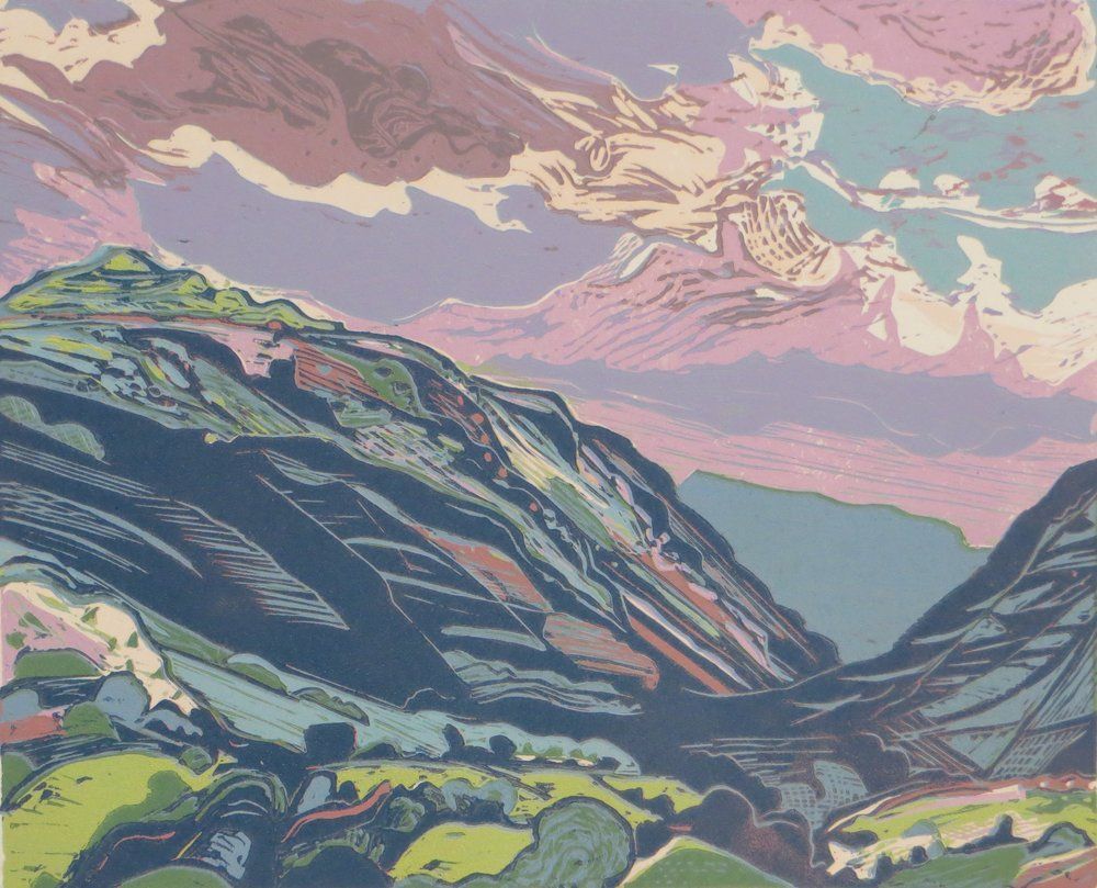 Colorful landscape of mountains and valley under a pink and purple sky