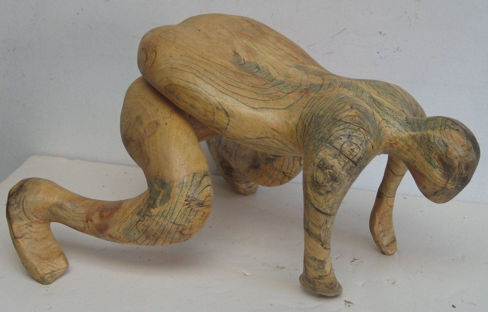 Wooden sculpture of a figure crawling