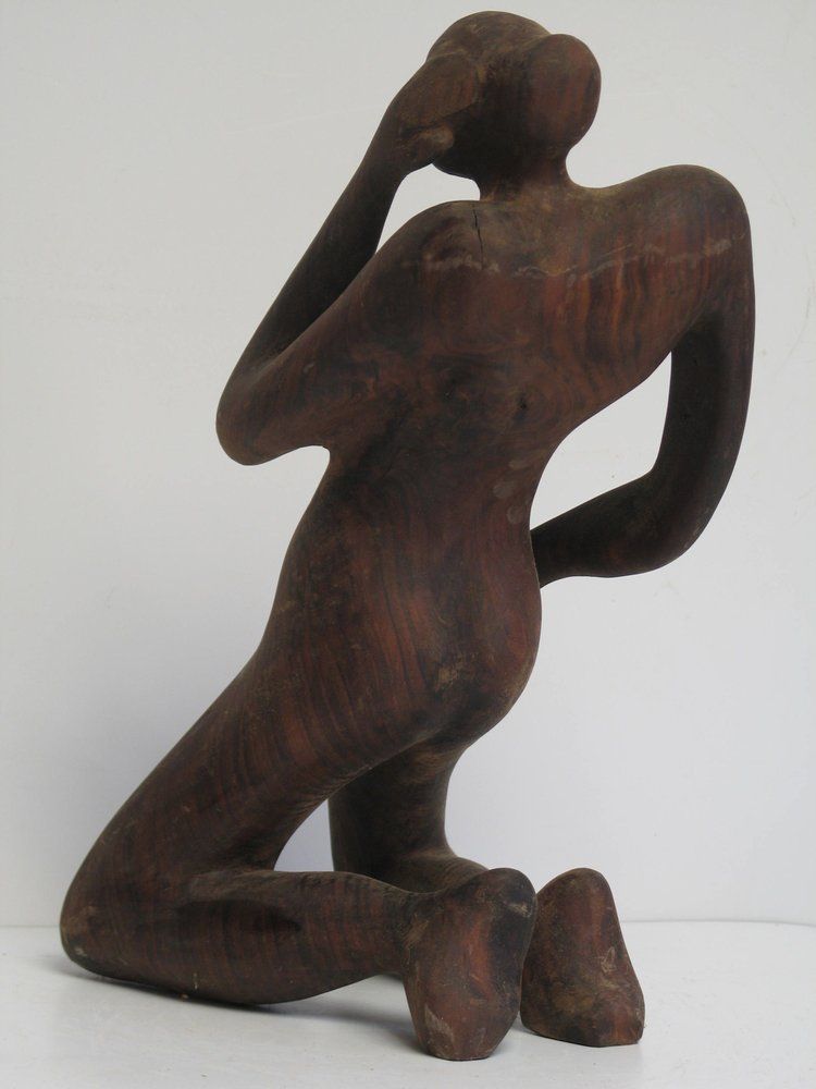 Wooden sculpture of a person kneeling