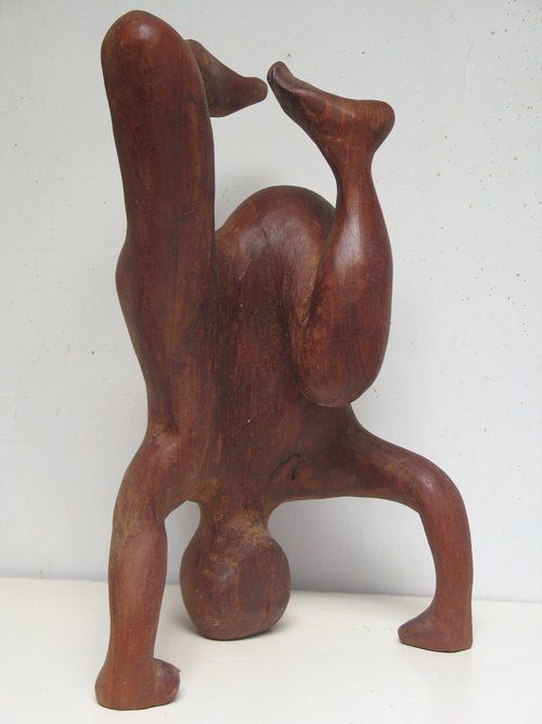Wooden sculpture of a person doing a handstand