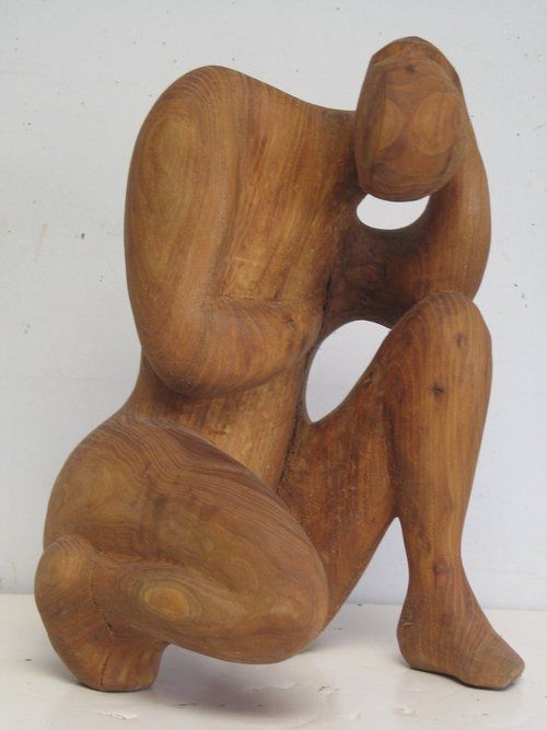 Wooden sculpture of a person crouching