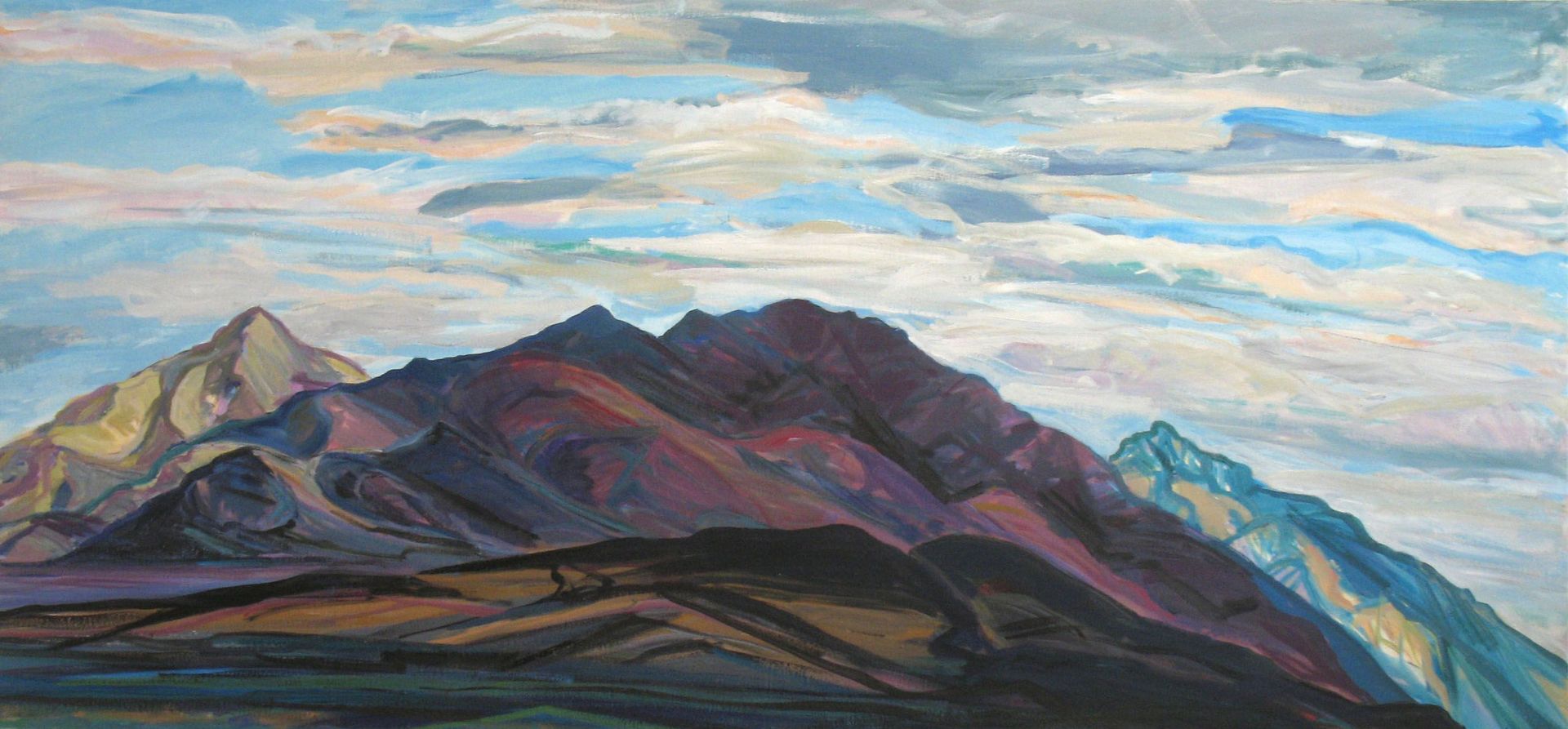 Colorful mountain range under a cloudy sky