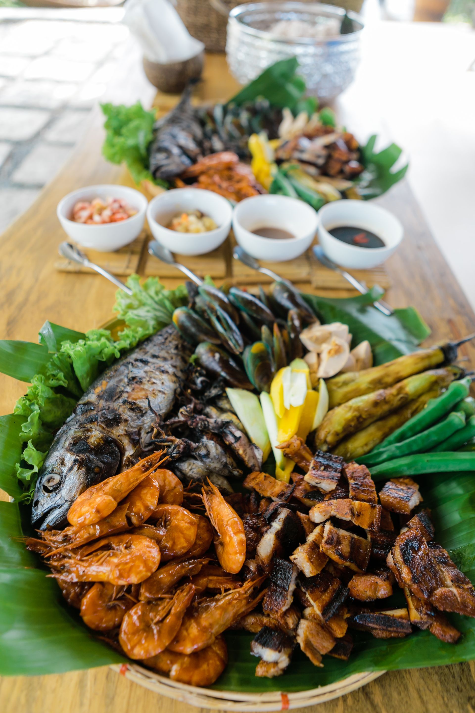 A large plate of food is sitting on a wooden table.