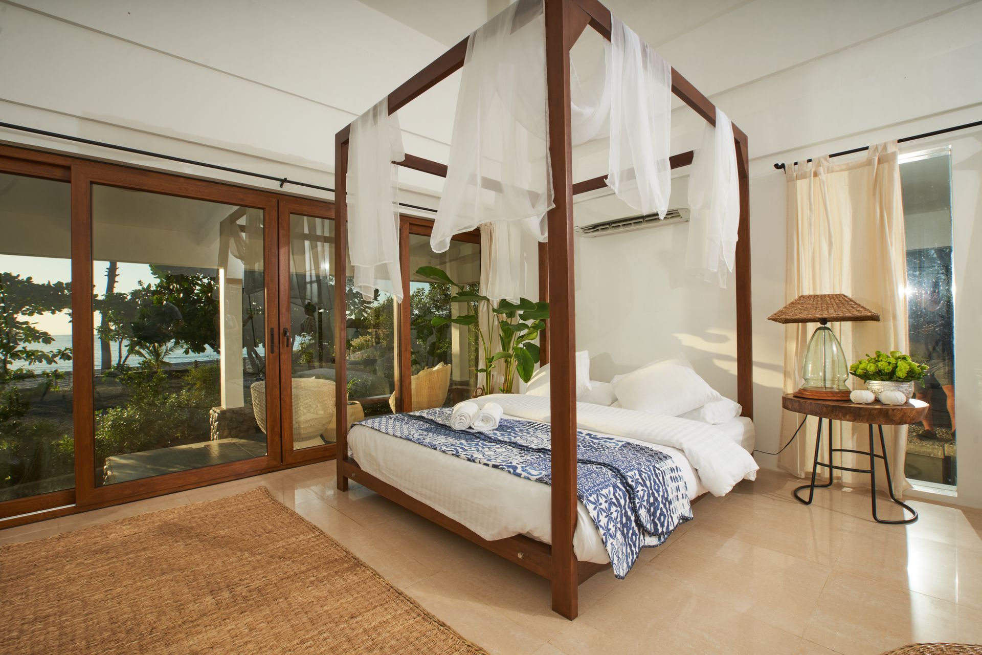 A bedroom with a canopy bed and lots of windows