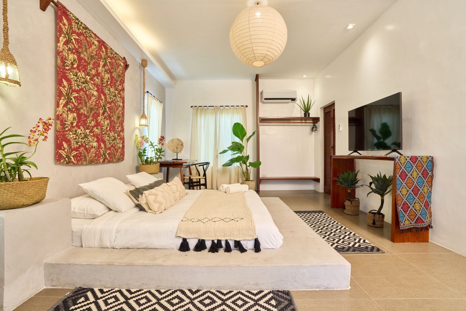 A bedroom with a large bed and a flat screen tv.