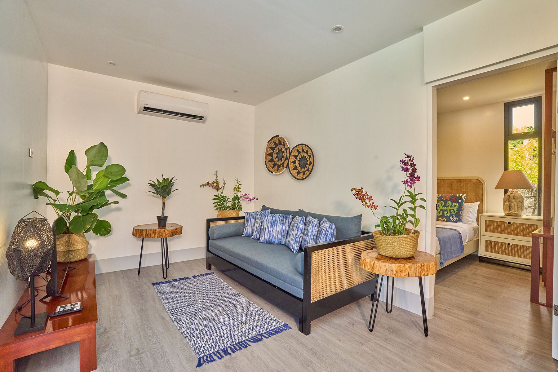 A living room with a couch , tables , and a bed.