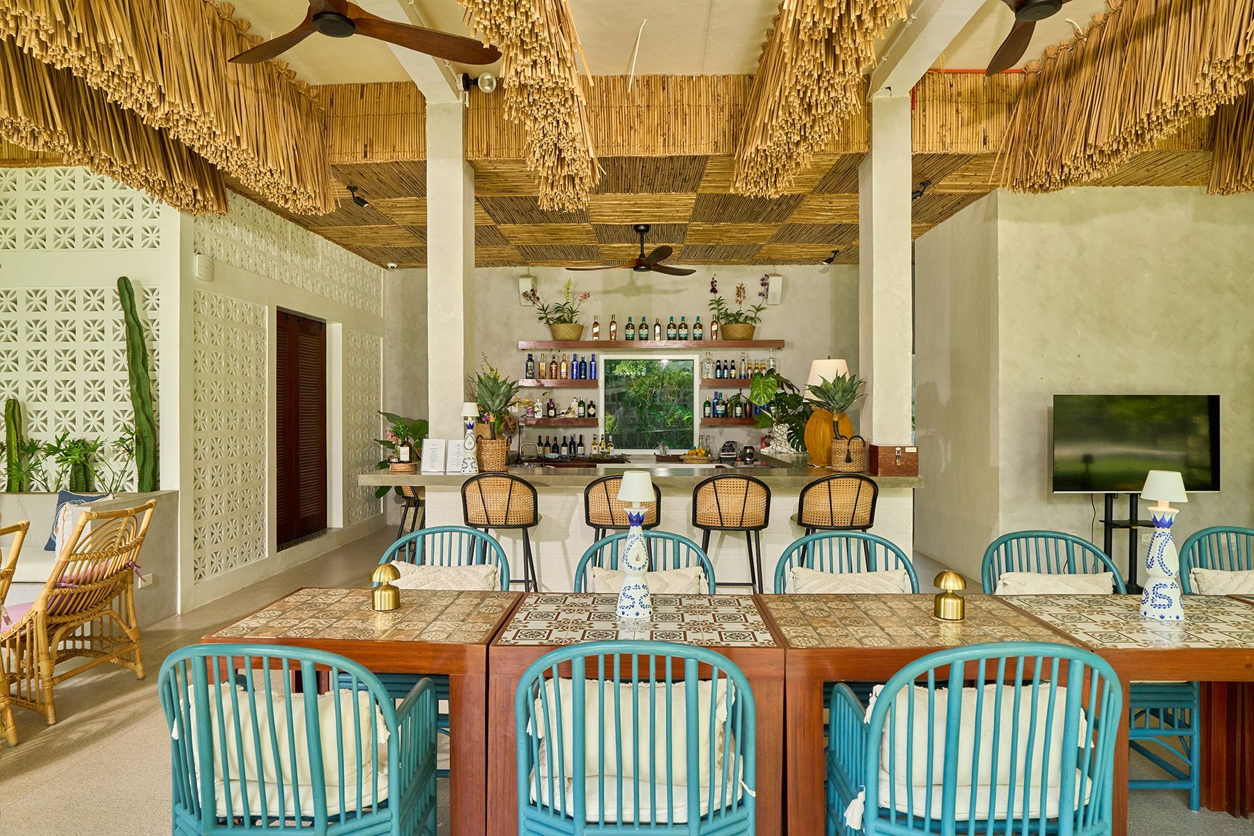 A dining room with tables and chairs and a bar.