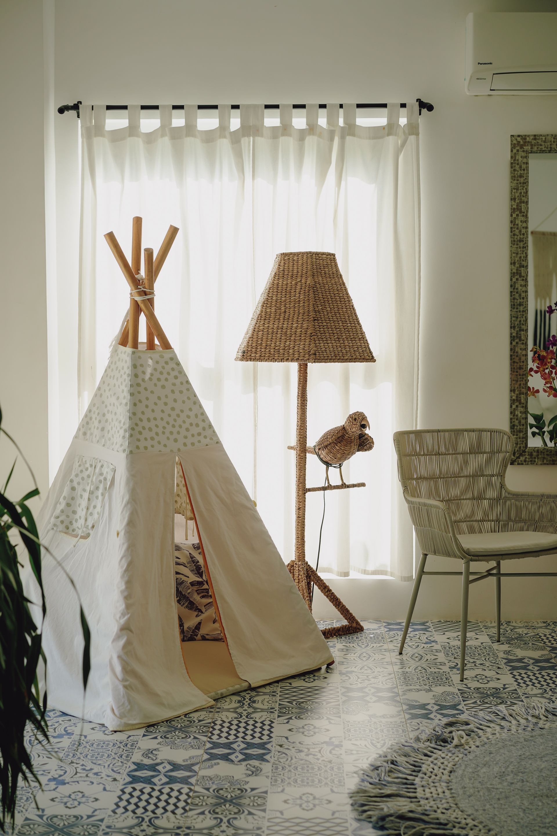 A teepee is sitting in a living room next to a lamp.