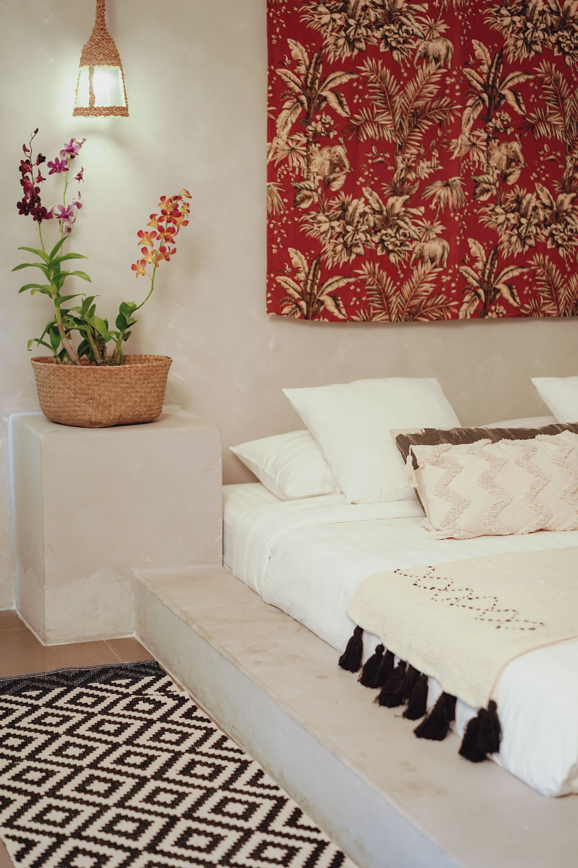 A bedroom with a bed , rug and a painting on the wall.