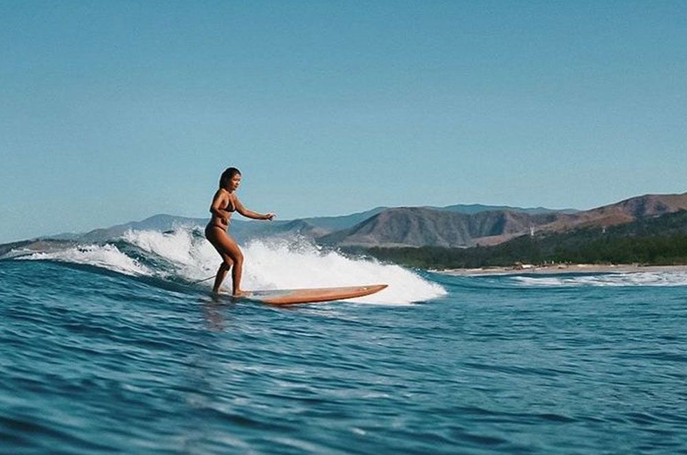 A woman is riding a wave on a surfboard in the ocean.