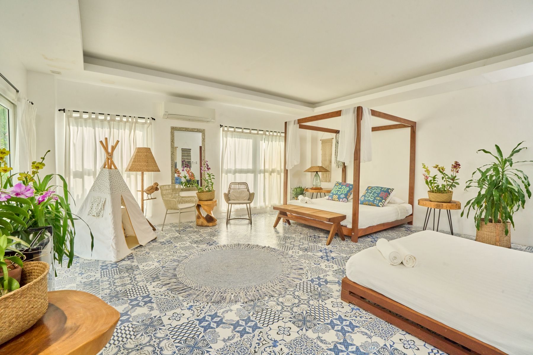 A large bedroom with a canopy bed and a teepee.