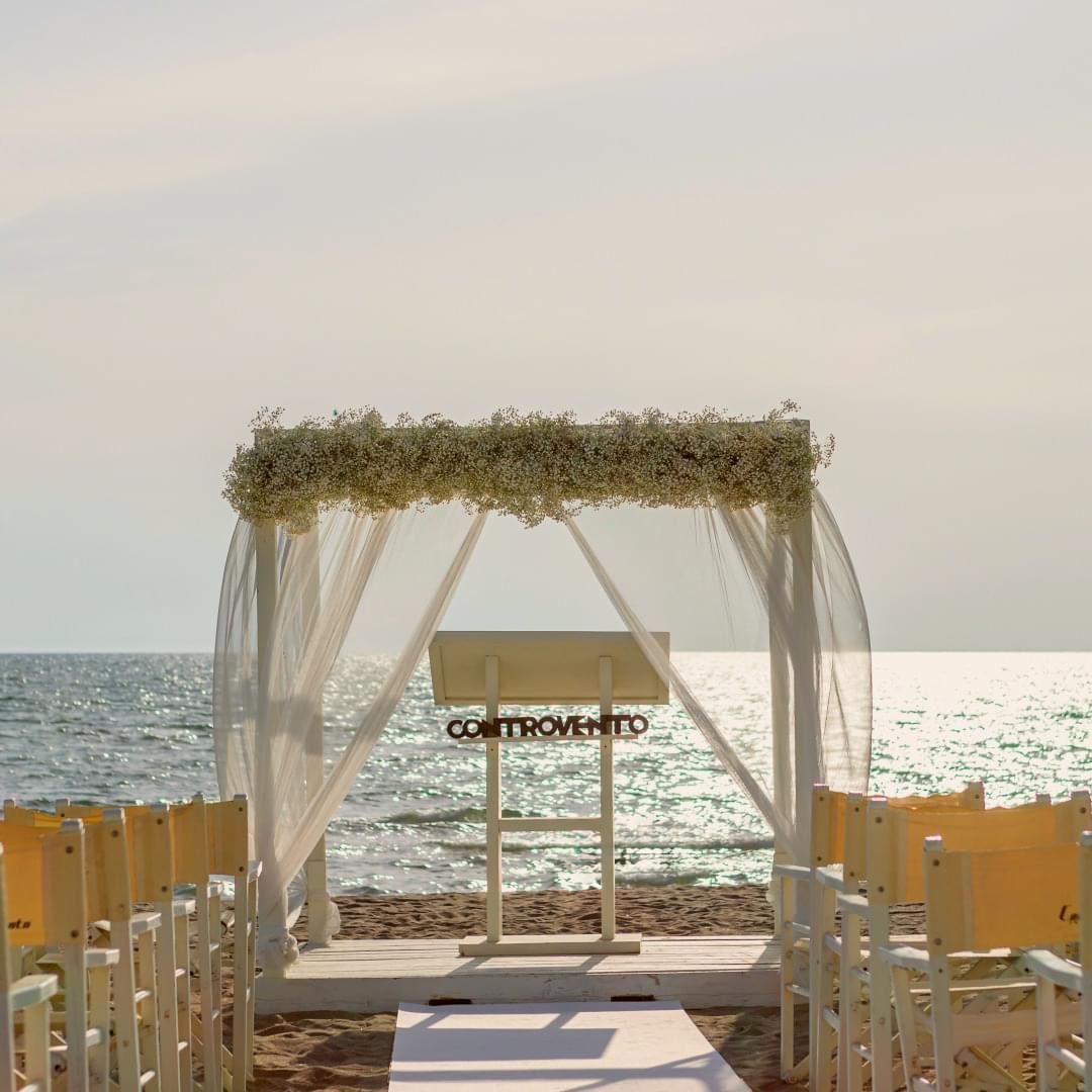 Allestimento per matrimonio sulla spiaggia con arco floreale