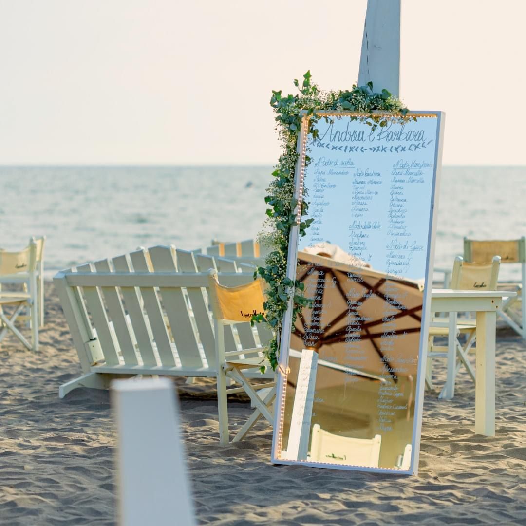 Specchio con mappa dei posti a sedere su una spiaggia. Sedie bianche, verde e oceano sullo sfondo.