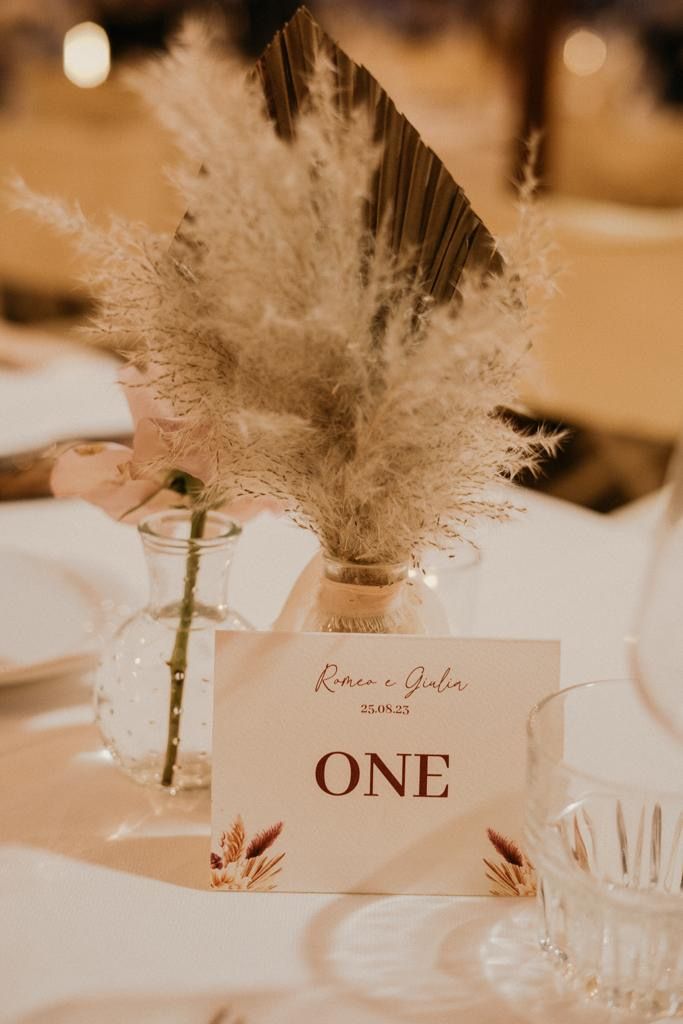 Apparecchiatura della tavola con composizione floreale e segnaposto con la scritta