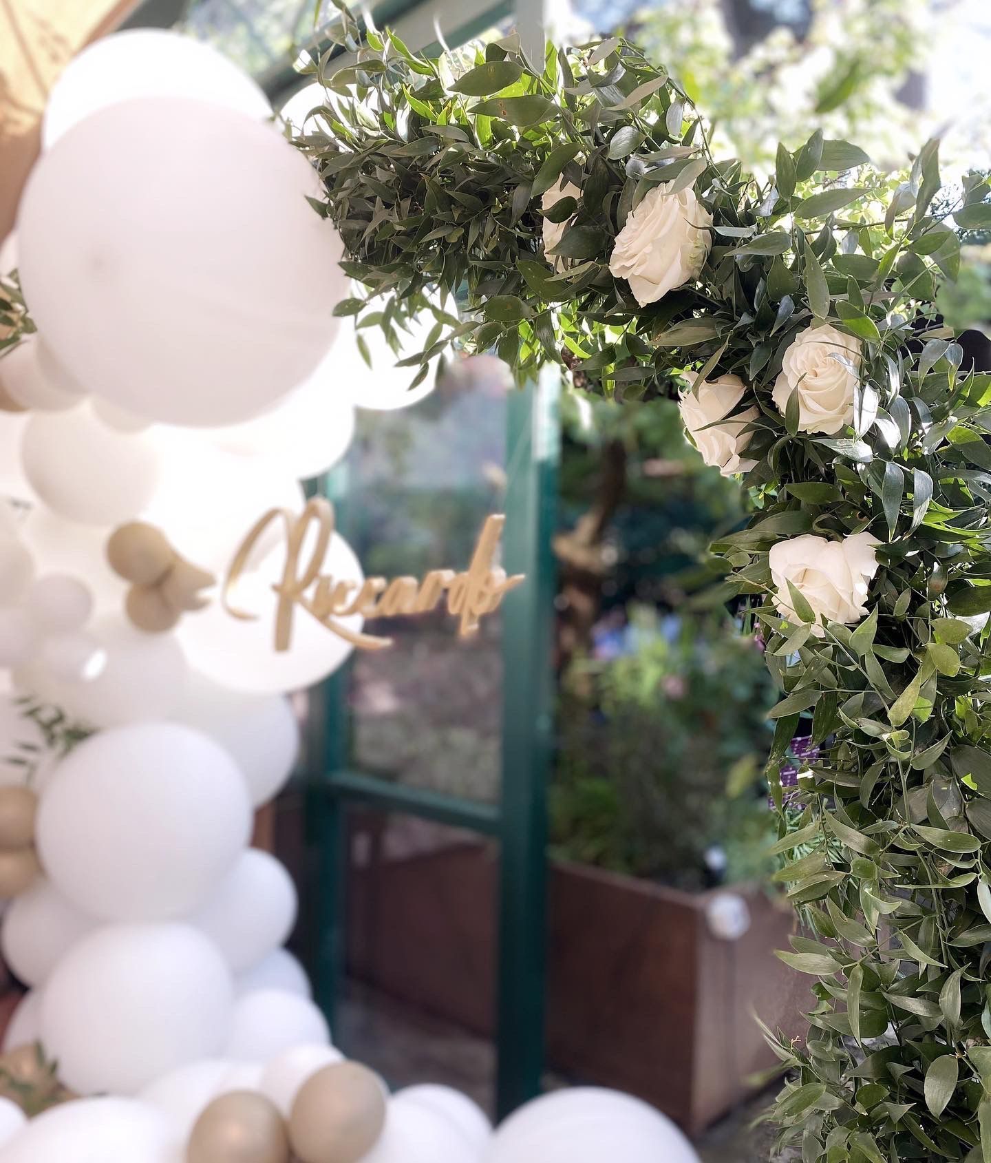 Arco decorato con palloncini bianchi, verde e rose bianche