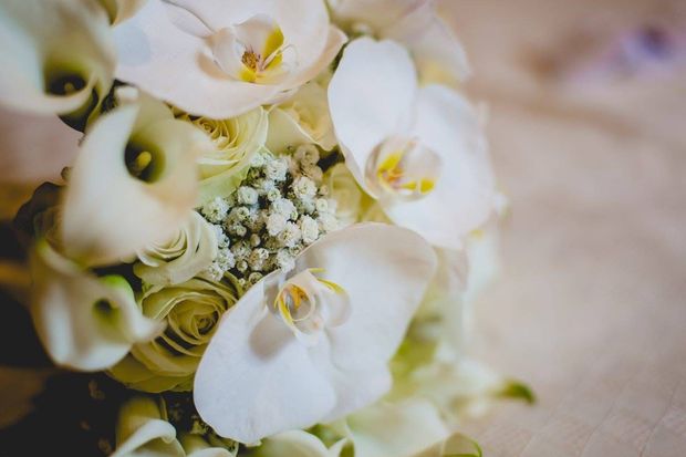 Orchidee bianche e calle in un bouquet, con rose e gypsophila.