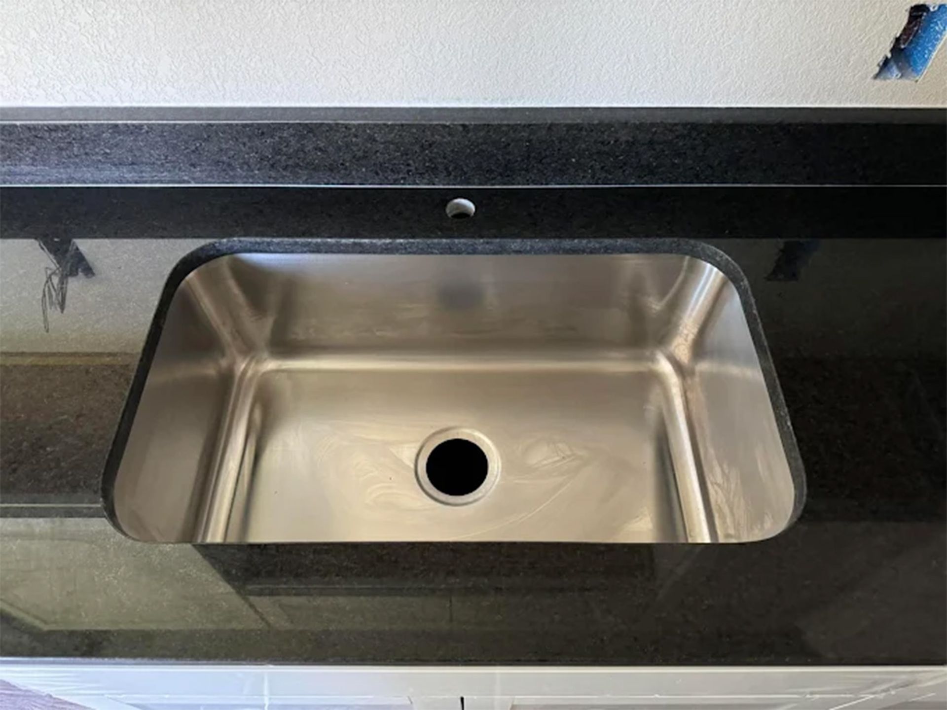 A bathroom with a toilet , sink , mirror and walk in shower.
