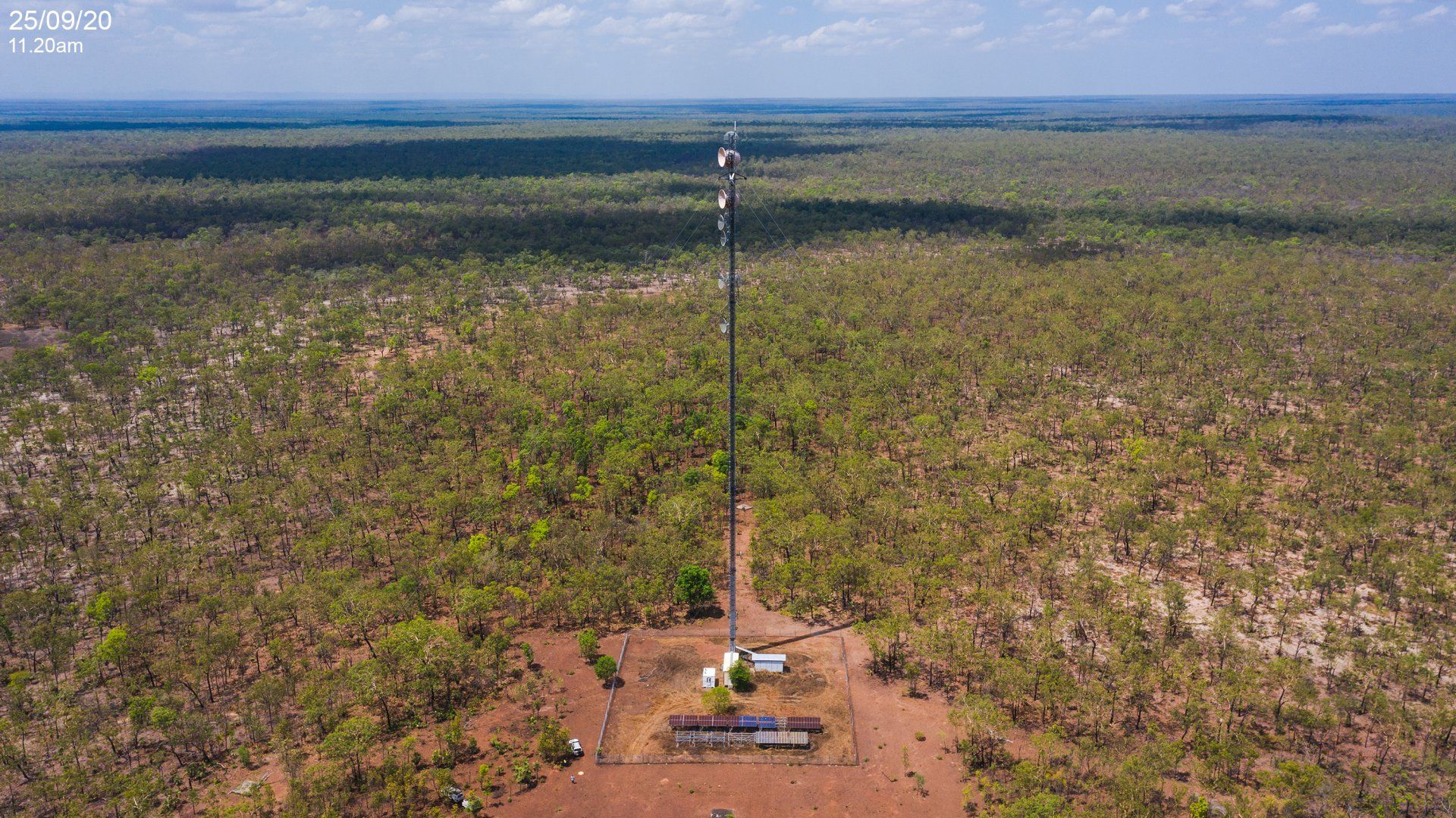 An aerial view of a tower in the middle of a forest.