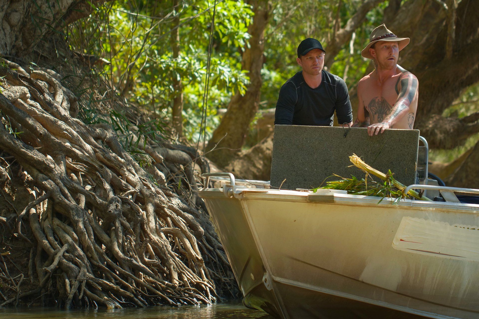 Two men are sitting in a boat on a river.