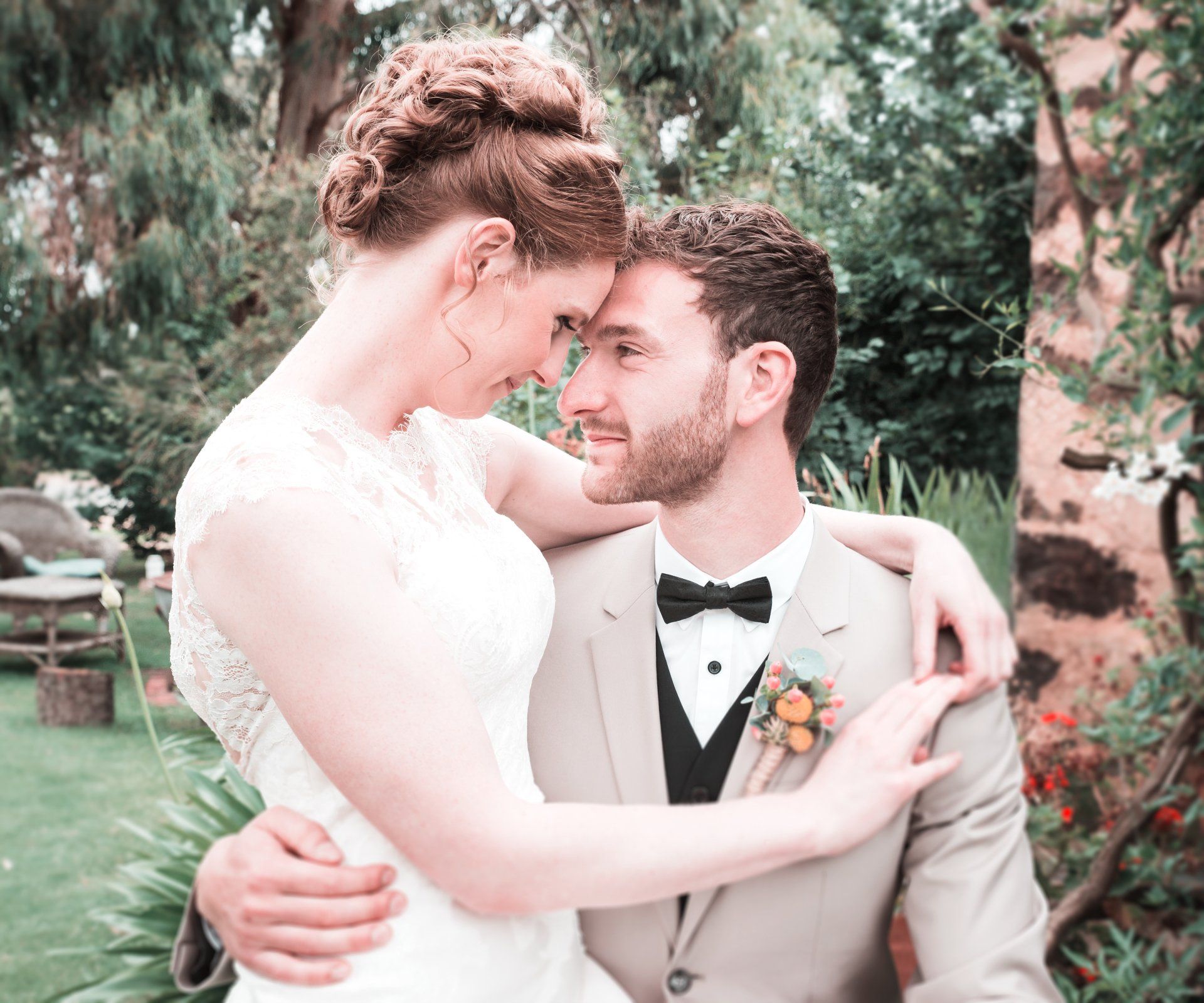 A bride and groom are hugging and looking at each other.