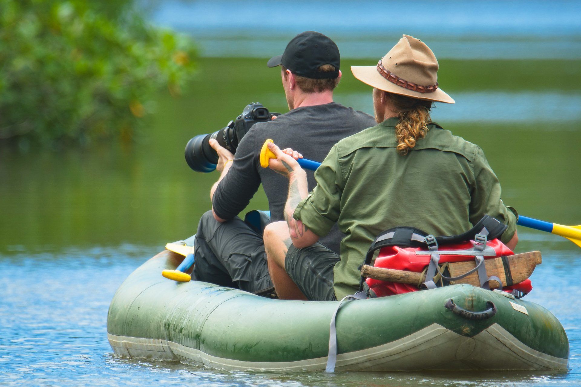 A man is taking a picture of a woman in a raft.