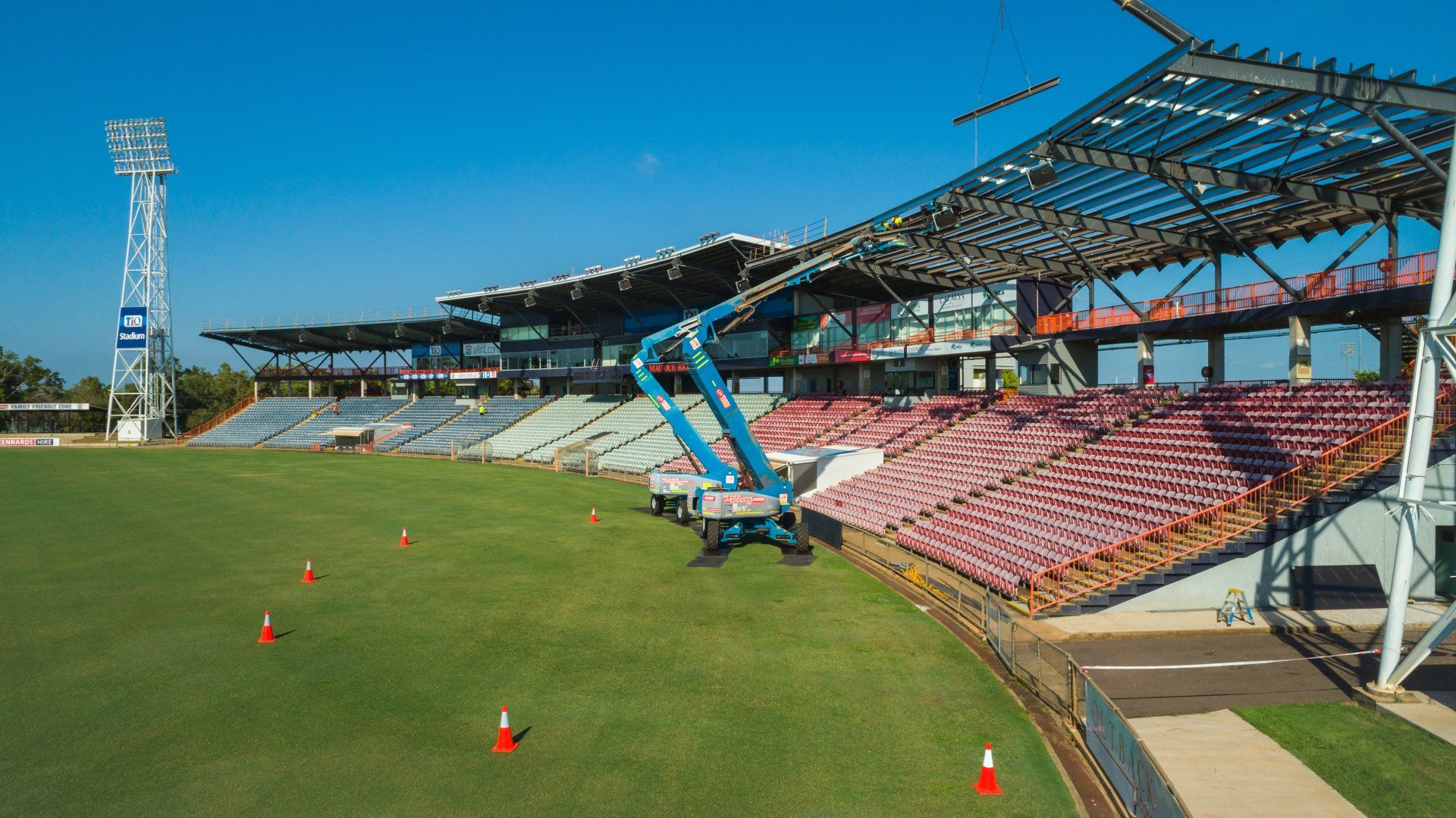 A stadium under construction with a crane in the foreground.