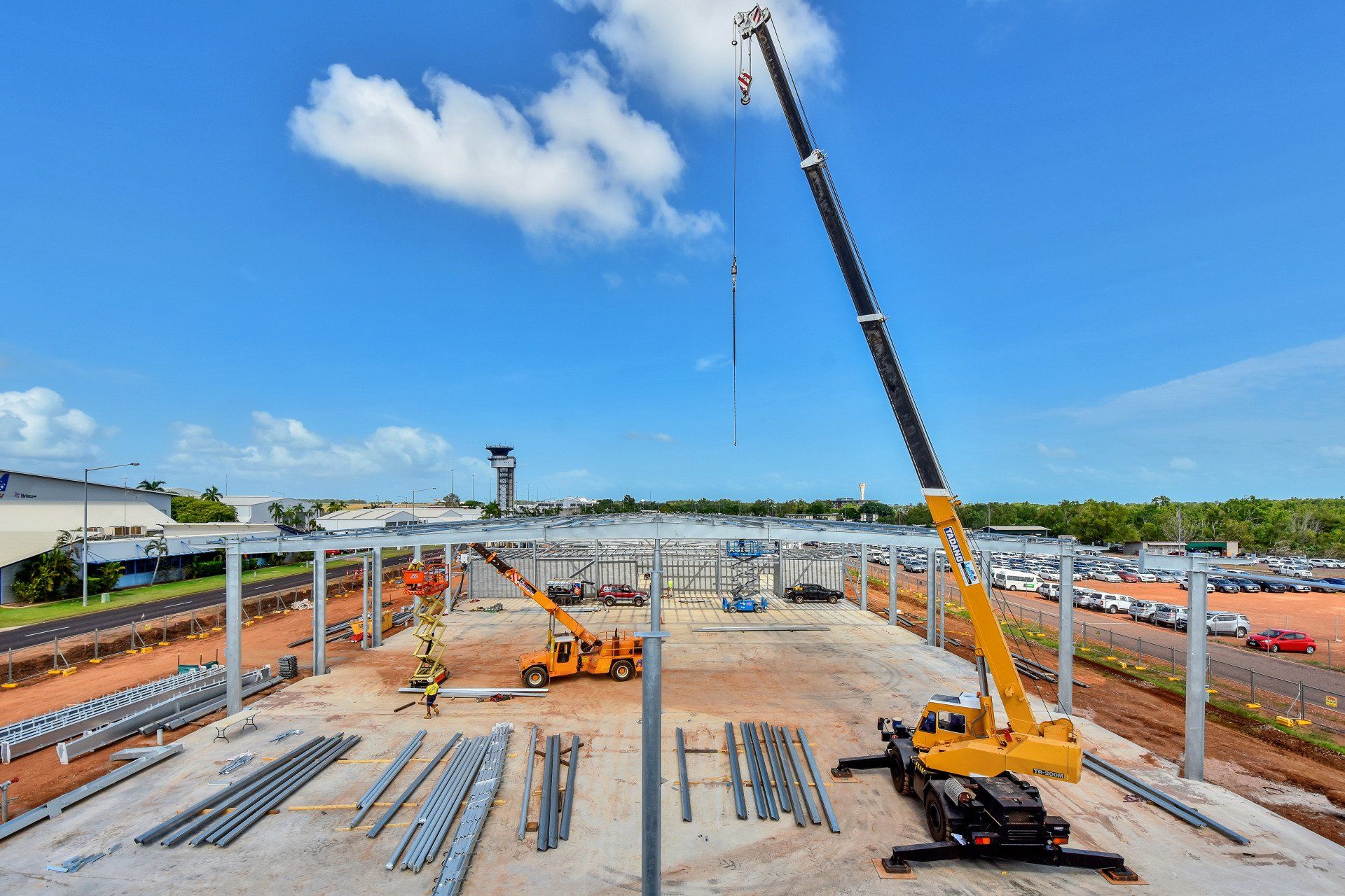 A large yellow crane is sitting on top of a construction site.