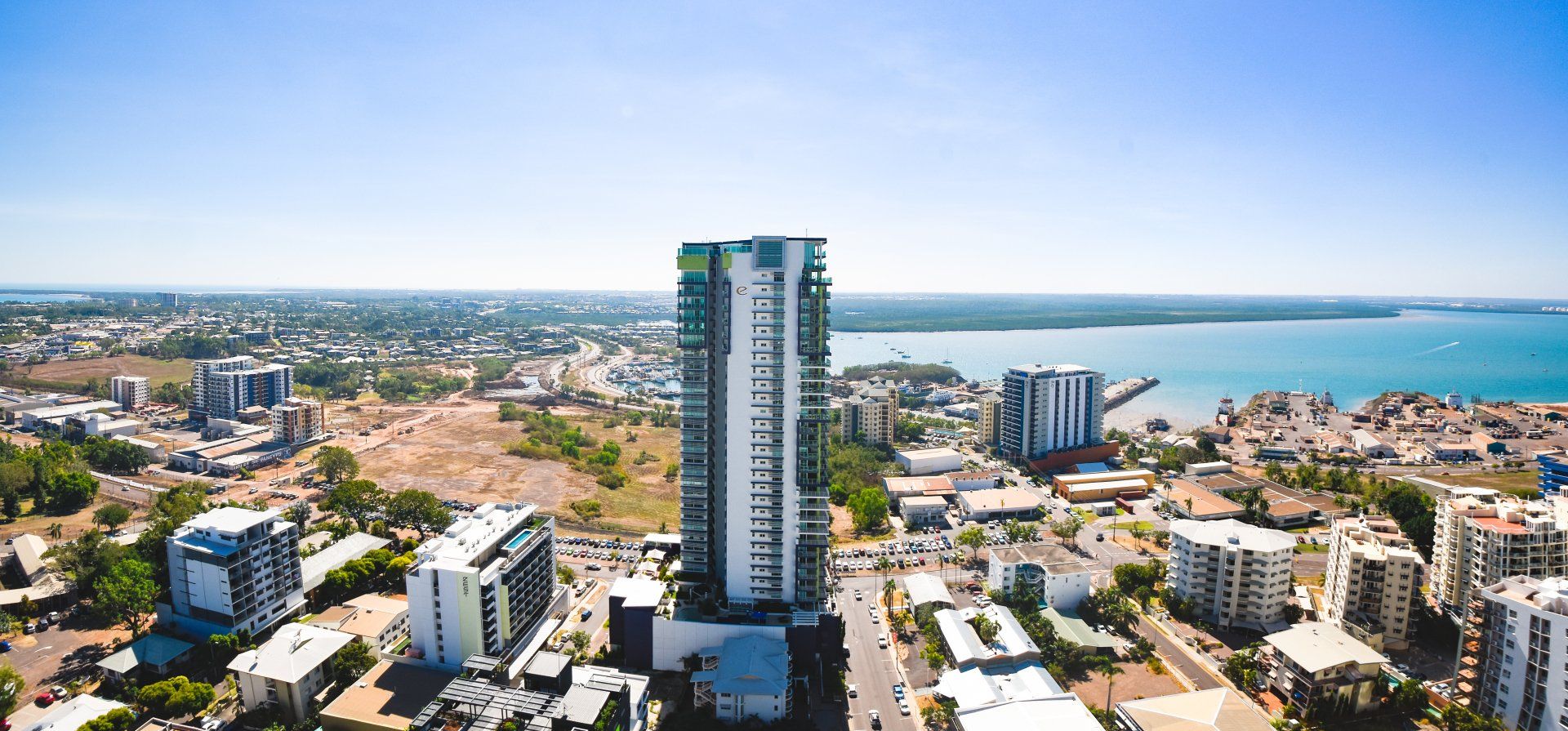 An aerial view of a city with a large building in the middle.
